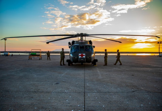 Soldiers with 3rd Assault Helicopter “Nightmare” Battalion, 1st Aviation Regiment, 1st Combat Aviation Brigade (1CAB), 1st Infantry Division work together to fold the blades of a UH-60 Black Hawk helicopter as the sun sets at the port of Alexandroupoli, Greece, Nov. 20, 2021. The 1CAB was preparing to load the aircraft onto the shipping vessel ARC Independence, as they were replaced by the 1st Air Cavalry Brigade, 1st Cavalry Division. 