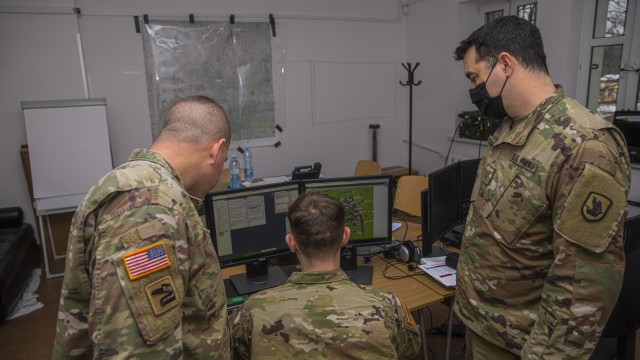 U.S. Army Washington National Guard Soldiers view simulated friendly forces on the command post of the future software system during a command post exercise in Bemowo Piskie Training Area, Poland, Dec. 7, 2021. These Soldiers served in the higher control cell, providing support for the training audiences as they exercised their warfighting capabilities. (U.S. Army photo by Spc. Jameson Harris)