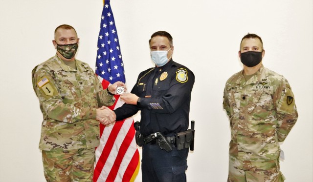 Lt. Benjamin Finn with the Directorate of Emergency Services Police Department receives a Commander's Coin of Excellence on Dec. 2, 2021, from Fort McCoy (Wis.) Garrison Commander Col. Michael Poss as part of the Garrison Command Team who...