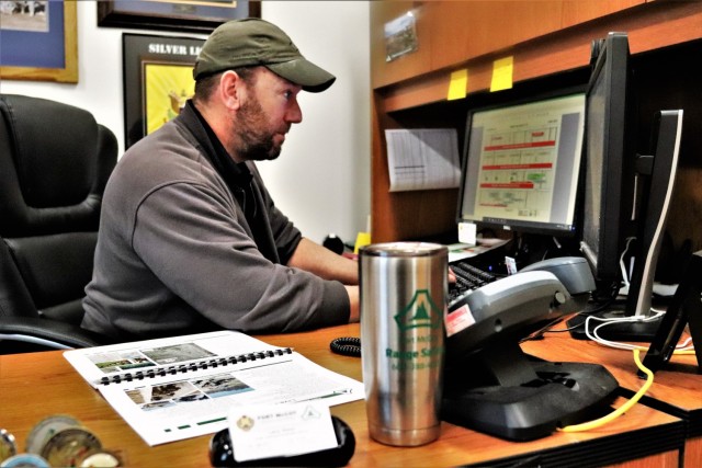 Fort McCoy Directorate of Plans, Training, Mobilization and Security (DPTMS) Chief of Training Coordination Larry Sharp works at his desk Dec. 9, 2021, at Fort McCoy, Wis. Sharp and many others from Fort McCoy DPTMS have been players and...