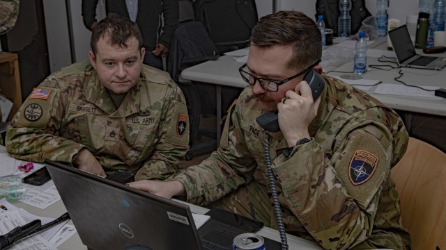 U.S. Army National Guard 1st Lt. Nicholas Pace and Sgt. Matthew Brissett, assigned to 3rd Battalion, 161st Infantry Regiment, part of the lower control cell, receive orders from higher control cell via telephone during a command post exercise in Bemowo Piskie Training Area, Poland, Dec. 7, 2021. The LOCON team was vital in the coordination between the upper echelon and the battalion staff during the exercise Rifle Focus II. (U.S. Army photo by Spc. Jameson Harris)