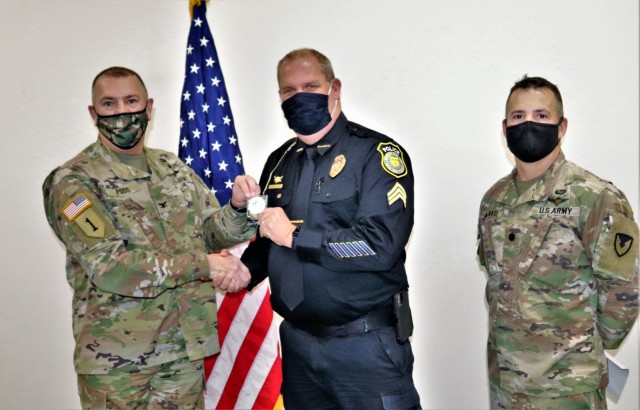 Sgt. Kevin Eckelberg with the Directorate of Emergency Services Police Department receives a Commander's Coin of Excellence on Dec. 2, 2021, from Fort McCoy (Wis.) Garrison Commander Col. Michael Poss as part of the Garrison Command Team who...