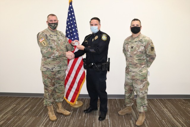 Lt. Benjamin Finn with the Directorate of Emergency Services Police Department receives a Commander's Coin of Excellence on Dec. 2, 2021, from Fort McCoy (Wis.) Garrison Commander Col. Michael Poss as part of the Garrison Command Team who...