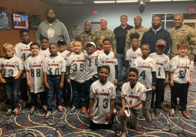Fort Jackson's Falcon 8 and under football team pose for a photo with Brig. Gen. Patrick R. Michaelis, U.S. Army Training Center and Fort Jackson commanding general, Post Command Sgt. Maj. Philson Tavernier, Coach Darius Lane, and team staff...