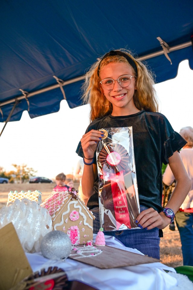 Brooklynne Cox won first place in Design and Blueprint for her gingerbread house and blueprints she created with the help of her Family before the start of the annual Holiday Tree Lighting Ceremony. More than 200 Soldiers, veterans, civilians and...