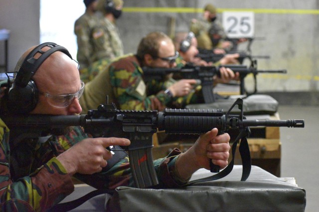 Adjutant Peter Van Den Block, a reservist with the Belgian armed forces who also works with the U.S. Department of State, aims an M4 carbine. U.S. Army military police Soldiers helped their Belgian counterparts qualify on U.S. Army weapons Dec. 7...