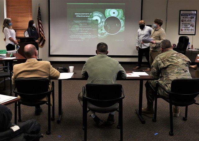 Fort Knox Garrison leaders Commander Col. Lance O’Bryan, Command Sgt. Maj. William Fogle and Garrison Deputy Jim Bradford listen to students during a Leadership Academy group presentation Dec. 9, 2021.