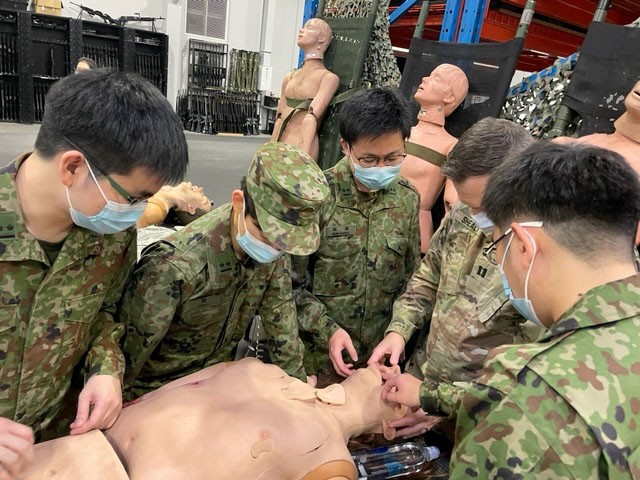 Dr. (Capt.) T. Ryan Shealy, an Army dentist assigned to Dental Health Command-Pacific, demonstrates a combat simulation mannequin to his Japan Ground Self-Defense Force dental colleagues during joint training at Camp Zama, Japan.