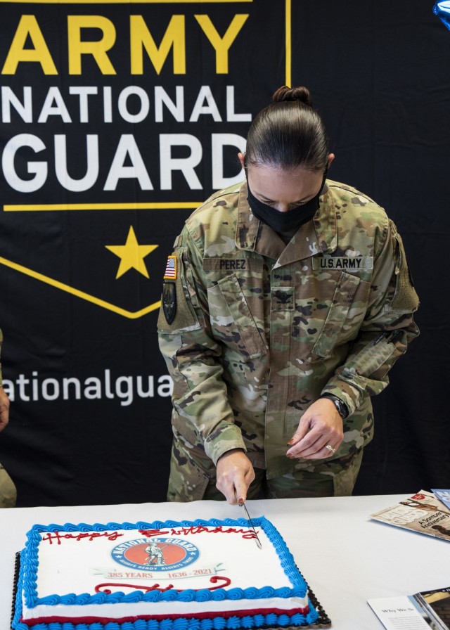 Col. Aracelis Perez, senior National Guard Advisor, U.S. Army Sustainment Command, cuts the first slice of the National Guard birthday cake at Rock Island Arsenal, Illinois, Dec. 13. The heritage of the National Guard dates back to Dec. 13, 1636,...