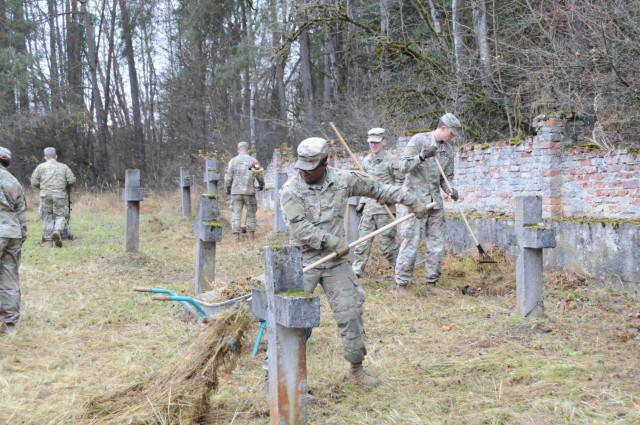 Soldiers from the 1st Armored Brigade Combat Team, 1st Infantry Division, cut grass, rake leaves and cart off debris at the Polish prisoner of war cemetery, located within the U.S. Army Garrison Bavaria Hohenfels Training Area, Nov. 19, 2021. 