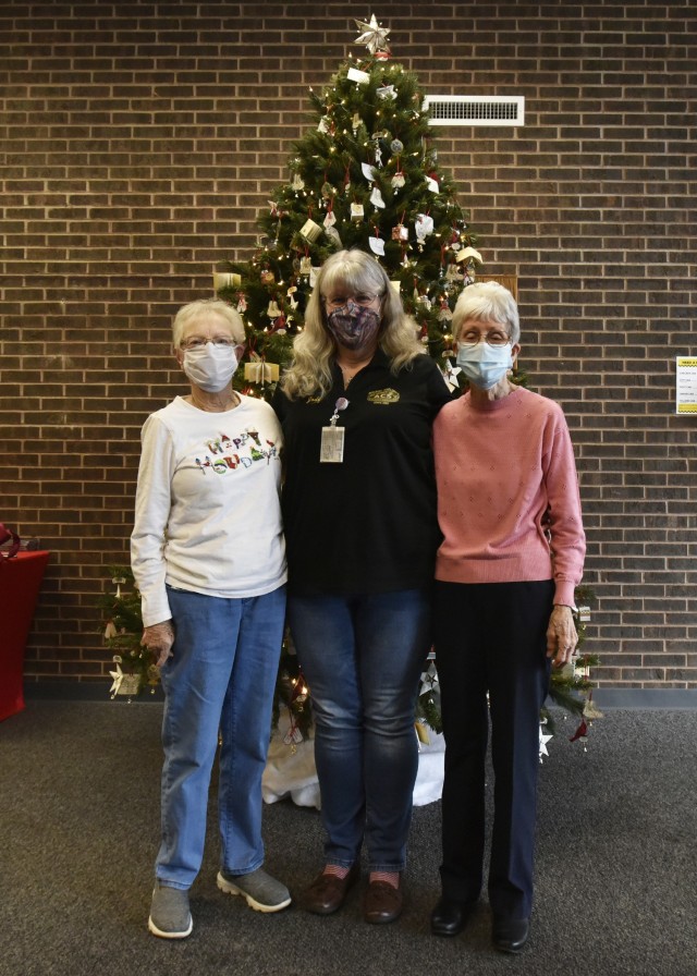 Survivor Outreach Services Coordinator Jody Carmack (center) poses for a photo with survivors Lois Robbins (right) and Kathryn Rushing in front of the Angel Bell Remembrance Tree Friday in the Army Community Service building. Each year since 2012,...