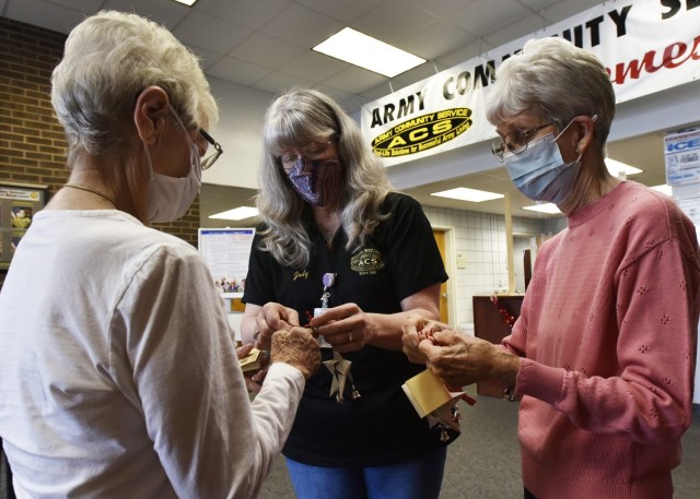 Survivor Outreach Services Coordinator Jody Carmack (center) sorts ornaments with survivors Lois Robbins (right) and Kathryn Rushing Friday in the Army Community Service building. Each year since 2012, the Angel Bell Remembrance Tree sits in the...