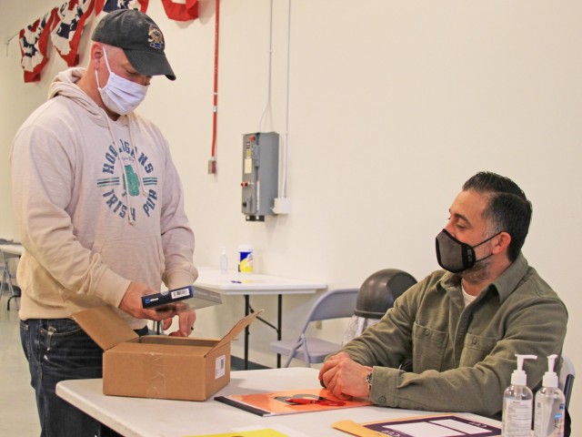 Scott Zelenock (left) and Pat Gutierrez (right), both of the Detroit Arsenal Garrison Directorate of Operations, unpack rapid COVID-19 test kits to test the unvaccinated work force coming onto the arsenal.