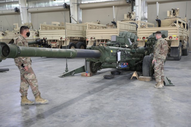 Soldiers from the 1st Theater Sustainment Command, Operational Command Post observe equipment which has been staged as part of the 401st Army Field Support Battalion-Kuwait’s and the Army’s Prepositioned Stock program at Camp Arifjan, Kuwait...