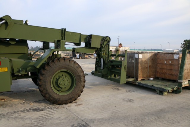 Soldiers assigned to the brigade support operations office in the "Maintain Battalion," 703rd Brigade Support Battalion, 2nd Armored Brigade Combat Team, 3rd Infantry Division, use a forklift to clear excess material from the 9th Brigade Engineer...