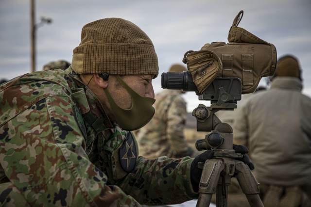 A member of the Japanese Ground Self-Defense Force looks through a spotter scope at practice targets downrange during training exercise Rising Thunder on December 5, 2021 at Yakima Training Center, Wa.