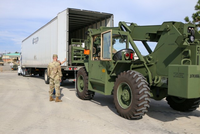 A Soldier assigned to the brigade support operations office in the "Maintain Battalion," 703rd Brigade Support Battalion, 2nd Armored Brigade Combat Team, 3rd Infantry Division, facilitates loading of excess material from the 9th Brigade Engineer Battalion motor pool onto a Defense Logistics Agency semi-trailer truck at Fort Stewart, Georgia, Dec. 6, 2021. This consolidated divestiture of excess materiel was completed in preparation of the brigade executing the Regionally Aligned Readiness and Modernization Model. (U.S. Army photo by Sgt. Trenton Lowery)