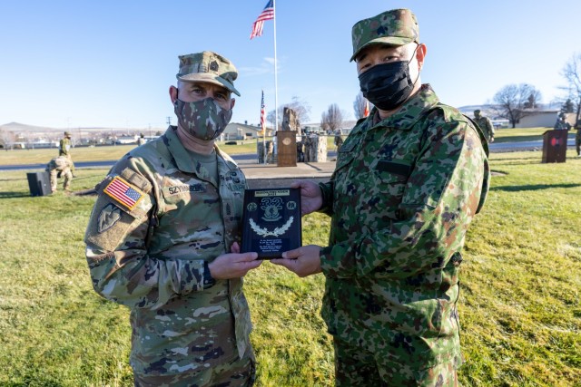 Warrant Officer Nishiue Masamichi, a member of the Japanese Ground Self-Defense Force, presents a plaque to Command Sgt Maj. Robert Szymaszek, 2nd Stryker Brigade Combat Team, 7th Infantry Division to commemorate the conclusion of a weeks-long training event during training exercise Rising Thunder on December 14, 2021 at Yakima Training Center, Wa.

  - Photo courtesy of Sgt. Ayato Takai, Japanese Ground Self-Defense Force
