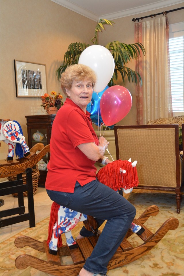 Inge Godfrey, Brooke Army Medical Center’s Fisher House manager, takes a ride on a rocking horse at the Fisher House, Fort Sam Houston, Texas, Oct. 21, 2016. Godfrey will retire at the end of 2021 with 29 years of service as BAMC’s Fisher House manager. (Courtesy Photo)
