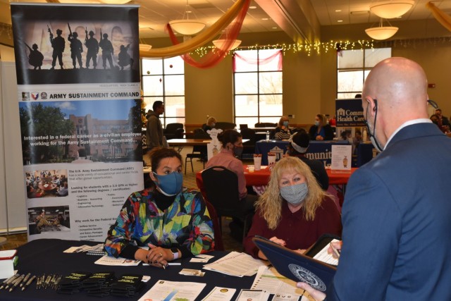 Melinda Verstraete (left) and Mary Kauzlarich from the U.S. Army Sustainment Command’s G-1 (Human Resources) give information about ASC to a participant in the fifth annual QC Success Fair Dec. 14 at St. Ambrose University in Davenport. (Photo...