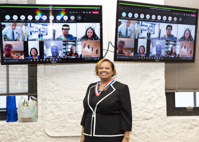 Hong Miller, Civilian Human Resources Agency deputy director, smiles for a photo with family and friends who could not attend in person her SES promotion ceremony. The event was held at Rock Island Arsenal, Illinois, Dec. 8, and livestreamed through Microsoft Teams. (Photo by Linda Lambiotte, ASC Public Affairs)