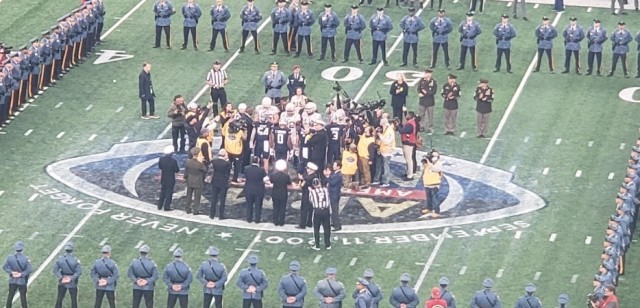 The Army Black Knights and the Navy Midshipmen meet at the 50 yard line for the coin toss during the 122nd Army-Navy Game.