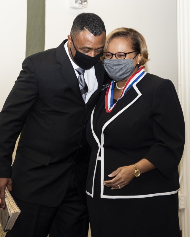 Hong Miller, Civilian Human Resources Agency deputy director, hugs her husband, Patrick, after being sworn into the Senior Executive Service at Rock Island Arsenal, Illinois, Dec. 8. (Photo by Linda Lambiotte, ASC Public Affairs)