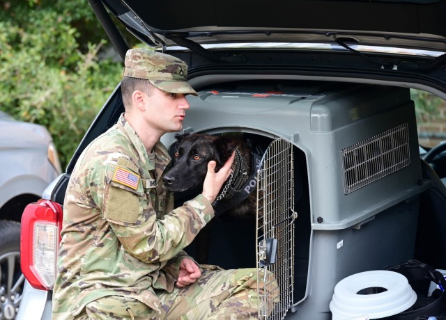 Pfc. Thomas Johnson, a Military Working Dog handler assigned to the 67th Military Police Detachment, Fort Leavenworth, Kan., reassures his MWD Fiona before they search a building for a suspect Dec. 13, 2021. The exercise is part of a series of events to certify MWD teams to perform their official duties and lend credibility to their findings is called into a court of law to testify. Eleven MWD Teams traveled to Fort Jackson, SC, for the week-long certification testing.