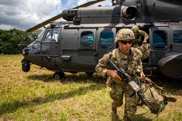 U.S. Army Soldiers with 1st Battalion, 187th Infantry Regiment, 3rd Brigade Combat Team, 101st Airborne Division (Air Assault) unload a Eurocopter AS532 Cougar during Exercise Southern Vanguard 22 in Lorena, Brazil, Dec. 3, 2021. U.S. and Brazilian army soldiers took part in the air assault exercise, which was the largest deployment of a U.S Army unit to train with the Brazilian army forces in Brazil. (U.S Army photo by Pfc. Joshua Taeckens)