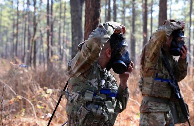 A soldier assigned to the 16th Military Police Brigade dons his mask during the best squad competition on Dec. 15, 2021, on Fort Bragg North Carolina. The competition consisted of the Army Combat Fitness Test, a stress shoot, a star course designed to assess squads on squad-level tasks and drills to include reacting to a CBRN threat, conducting a hasty defence, movement of a casualty to a medical site, reacting to contact, application of camouflage, and a mystery event dubbed brain games.
