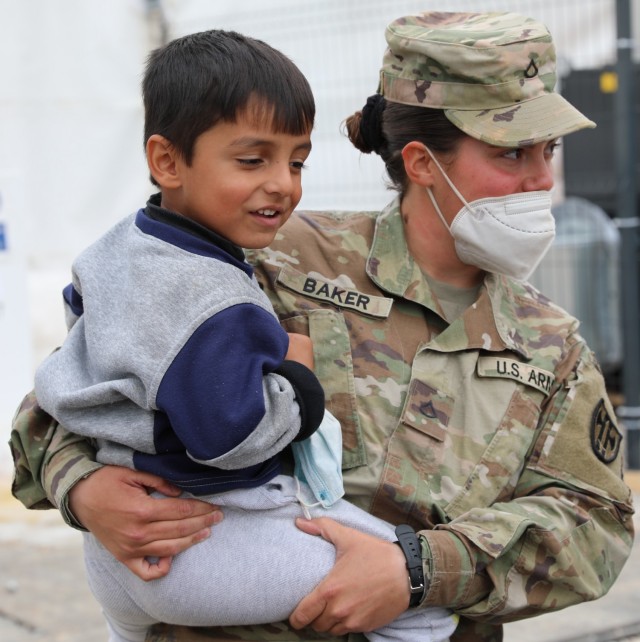 U.S. Army Pfc. Melissa Baker, a horizontal construction engineer with Task Force Ever Vigilant, holds an Afghan evacuee on Camp Liya, Kosovo, October 1, 2021.

U.S. - affiliated Afghans will temporarily stay in Kosovo during the onward movement to the United States. Task Force Ever Vigilant provides housing, medical, and logistical support to Afghan evacuees as they await the location of their final destination. Task Force Ever Vigilant is a combination of Soldiers from various units of the 21st Theater Sustainment Command.