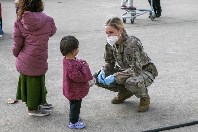 U.S. Army Spc. Sophia Harmelink, a multiple launch rocket system crewmember assigned to 1st Battalion, 77th Field Artillery Regiment, plays with a little Afghan girl on Sept. 30, 2021 at Ramstein Air Base, Germany. Approximately 175 Soldiers from 1-77 FAR, 41st Field Artillery Brigade have been assigned to support Operation Allies Welcome and augment the security force at the holding facilities at Ramstein providing life support for Afghan travelers awaiting follow on flights.