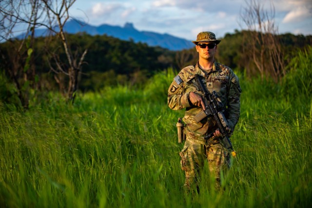 U.S. Army Soldier Staff Sgt. Shane Hayes, weapons squad leader with Bulldog Company, 1st Battalion, 187th Infantry Regiment, 3rd Brigade Combat Team, 101st Airborne Division (Air Assault) stands with his weapon during Exercise Southern Vanguard 22 in Resende, Brazil, Dec. 11, 2021. U.S. and Brazilian Army soldiers took part in the air assault exercise, which was the largest deployment of a U.S Army unit to train with the Brazilian Army forces in Brazil. (U.S Army photo by Pfc. Joshua Taeckens)