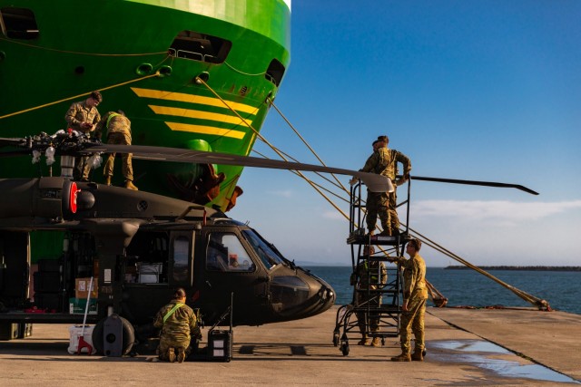 U.S. Army Soldiers with 1st Air Cavalry Brigade, 1st Cavalry Division, work together to unfold the blades of a UH-60 Black Hawk helicopter after its download from the vessel ARC Independence at the port of Alexandroupoli, Greece, Nov. 28, 2021. Greece provides tremendous training venues and conditions nearly year-round, specifically regarding winter training deployments for aviation rotations. 