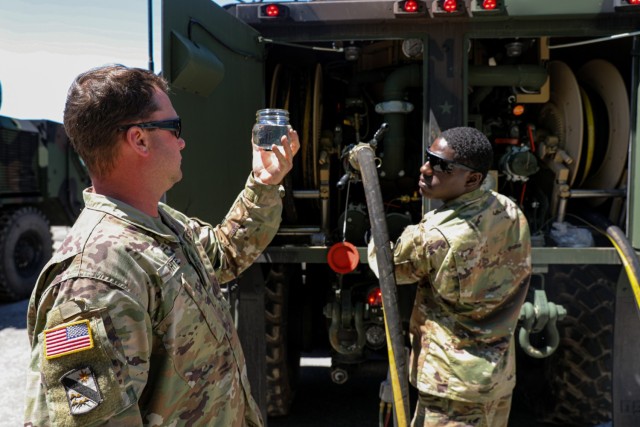 Sgt. Cody White and Spc. Zarion Moore, refuelers from Echo Company, 1-131st Assault Helicopter Battalion, Alabama Army National Guard, inspect a sample of fuel to determine if it has been properly filtered on May 22, 2021, at Tuzla International Airport, Bosnia. 