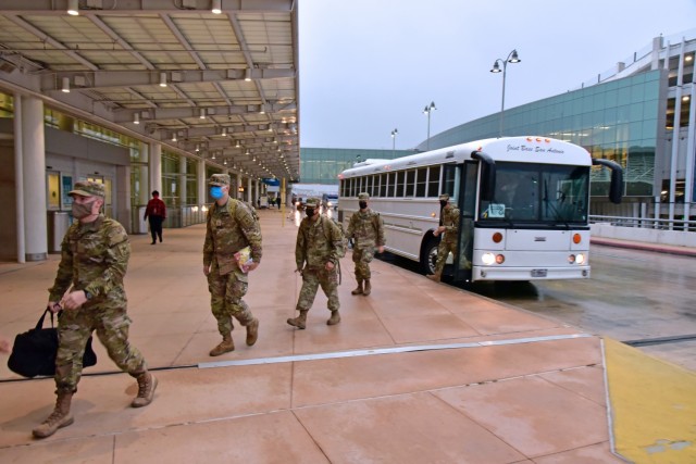 Soldiers departing a transport buss at the San Antonio International Airport for their Holiday Block Leave.