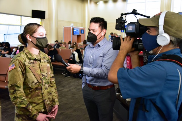 PV2 Sierra Reese, a 68C Practical Nursing Specialist, on a live broadcast interview by KSAT News reporter RJ Marquez. San Antonio is known as Military City USA, and the departure of this many Soldiers along with Airmen, Sailors, and Marines on similar holiday travel, is of great interest to the local community. Local news media covered the event.