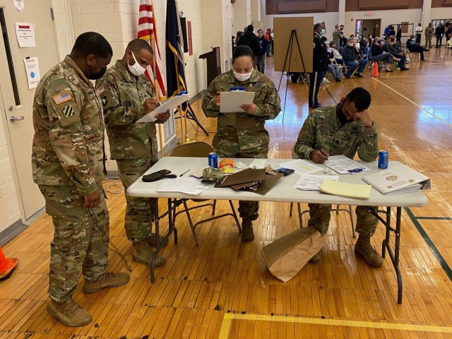 Sgt. 1st Class Lavonne Williams (right), U.S. Army Tank-automotive and Armaments Command’s Integrated Logistic Supports Center, evaluates JROTC cadets during the Michigan JROTC regional competition in Detroit, Dec. 11.