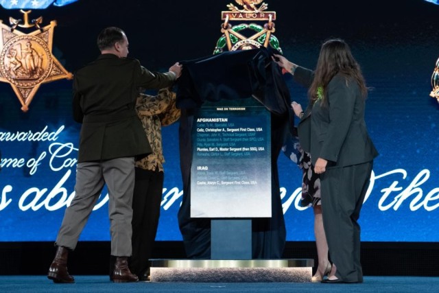 Master Sgt. Earl D. Plumlee; Tamara Cashe, spouse of Sgt. 1st Class Alwyn Cashe; Kasinal Cashe White, sister of Sgt. 1st Class Cashe; and Katherine Celiz, spouse of Sgt. 1st Class Christopher A. Celiz, uncover a Hall of Heroes plaque that will be displayed at the Pentagon during a Medal of Honor Induction Ceremony at Joint Base Myer-Henderson Hall, Va., Dec. 17, 2021. 