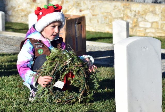 Callie Peryea, 7, a Girl Scout, says the name of a person buried at the Presidio of Monterey Cemetery before laying a wreath on Wreaths Across America Day at PoM, Calif., Dec. 18.