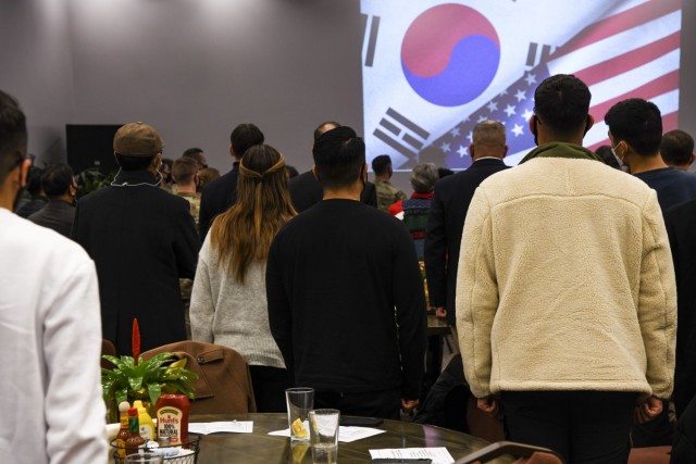 U.S. Army Garrison Humphreys service members and guests stand for the playing of the U.S. and Korean national anthems during the K6 Korea-America Friendship Association ROK-U.S. Friendship Night and year-end dinner at the Camp Humphreys Flightline Tap Room Dec. 15, 2021.