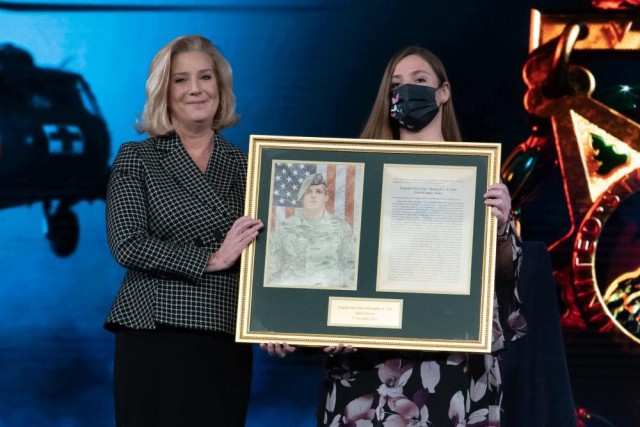 Katie Celiz, right, wife of Medal of Honor recipient Sgt. 1st Class Christopher Celiz, and Secretary of the Army Christine E. Wormuth, hold Celiz&#39;s honorary plaque after he was inducted into the Pentagon&#39;s Hall of Heroes on Dec. 17, 2021.  