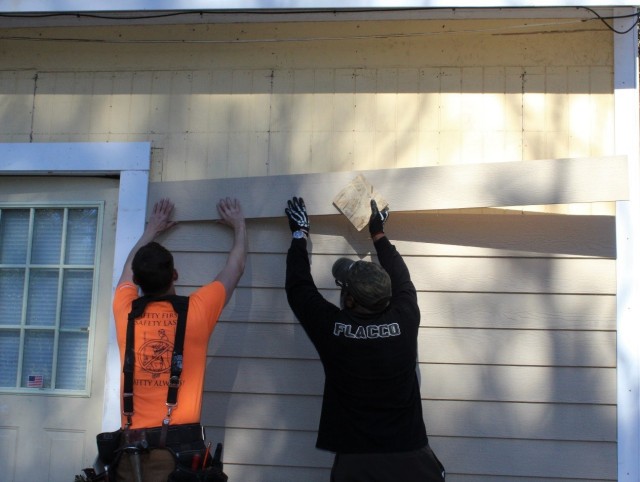 FORT BENNING, Ga. (Dec. 20, 2021) – U.S. Army Spc. James Labranche, left, and the House of Heroes volunteer attached outdoor fiber siding during BOSS week 2021 and the House of Heroes event on Dec. 12. 