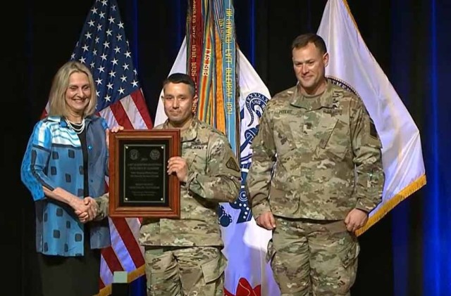 Lt. Col. Kris Haley, Product Manager Terrestrial Spectrum Warfare, accepts the 2021 Product Management Officer Team of the Year Award from Karen D. H. Saunders, Senior Official Performing the Duties of the Assistant Secretary of the Army for...