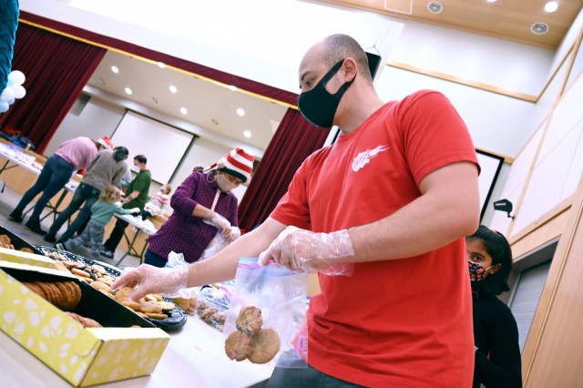 Spc. Ian Holmes, president of U.S. Army Garrison Humphreys Better Opportunities for Single Soldiers, helps sort cookies as part of Operation Holiday Cookie Drop Dec. 19, 2021 at Four Chaplains Memorial Chapel. (U.S. Army photo by Monica K. Guthrie)