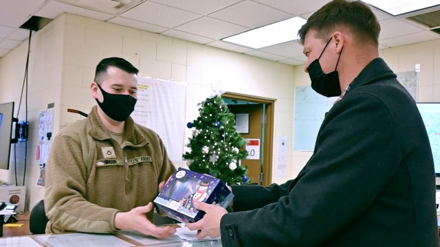 Maj. Ryan Stone, executive officer of 602nd Aviation Support Battalion, 2nd Combat Aviation Brigade delivers cookies to Private 1st Class Alexiz Marin, Headquarters and Headquarters Company, 3-2 General Support Aviation Battalion, 2nd Combat...