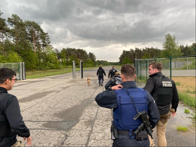 U.S. Soldiers and local national police clear an area at Army Prepositioned Stock (APS-2) Site Zutendaal, Belgium during an international manhunt May 2021. (U.S. Army photo by Maj. Denard Honeysuckle, USAG Benelux Directorate of Emergency Services)