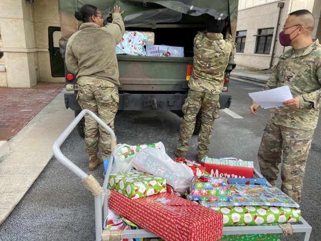 Soldiers from the U.S. Army Garrison Humphreys Religious Support Office check their list twice as they load gifts for military and South Korean children into a delivery vehicle for Operation Happy Holidays Dec. 20, 2021. (Photo courtesy of Chaplain (Maj.) Christian Bang)