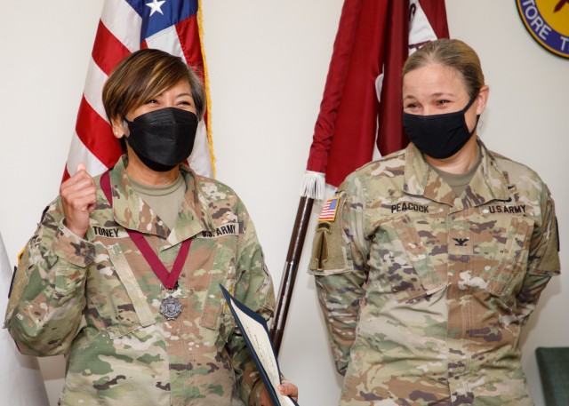 Lt. Col. Dolores &#39;Dolly&#39; Toney, a nurse practitioner and deputy commander for nursing at U.S. Medical Department Activity-Japan, gives a thumbs-up after being inducted into the Order of Military Medical Merit by Col. Tanya Peacock, right, commander, MEDDAC-Japan, on Dec. 14.
