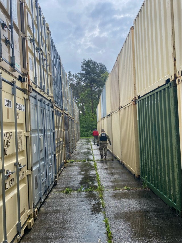 U.S. Soldiers and local national police clear a Conex area at Army Prepositioned Stock (APS-2) Site Zutendaal, Belgium during an international manhunt May 2021. (U.S. Army photo by Maj. Denard Honeysuckle, USAG Benelux Directorate of Emergency...